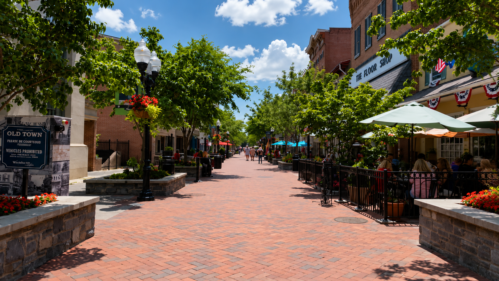 The Old Town Winchester walking mall, a sunny summer day with sidewalk cafes and trees.